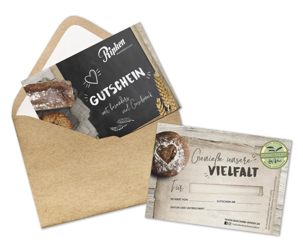 Ein brauner Umschlag mit einer Geschenkkarte mit dem Motiv einer Bäckerei im Inneren. Die Karte zeigt Brot, Weizen und einen Text auf Deutsch, darunter Gutschein und Genieße unsere Vielfalt auf einem rustikalen Holzhintergrund.