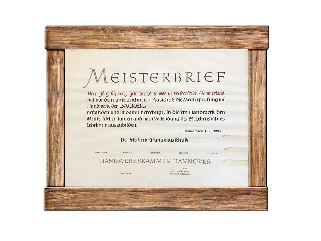 Gerahmter Deutscher Meisterbrief der Handwerkskammer Hannover, verliehen an Jörg Ripken zur Erlangung des Meistertitels im Bäckerhandwerk. Die Urkunde ist mit rustikalem Holz eingefasst.