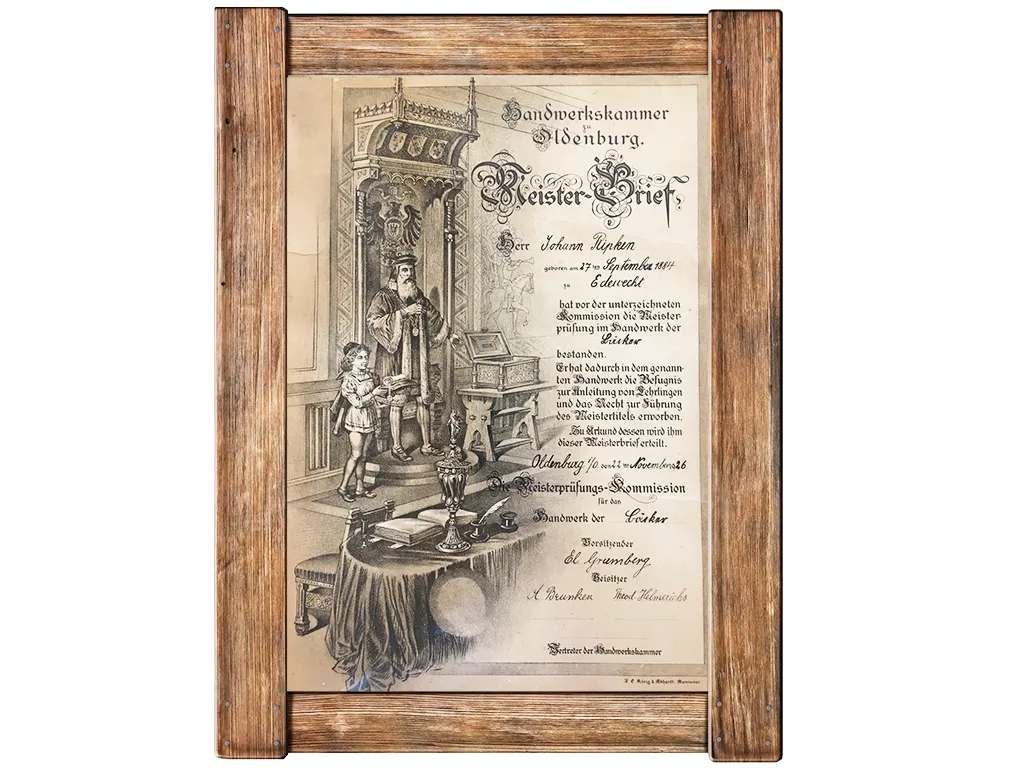 Gerahmtes, altes deutsches Zertifikat mit verschnörkeltem Text und detaillierter Illustration einer richterähnlichen Figur, die einem Mann ein Zertifikat überreicht, während ein Kind in der Nähe steht; beschriftet mit "Meister-Brief" und "Handwerkskammer Oldenburg".