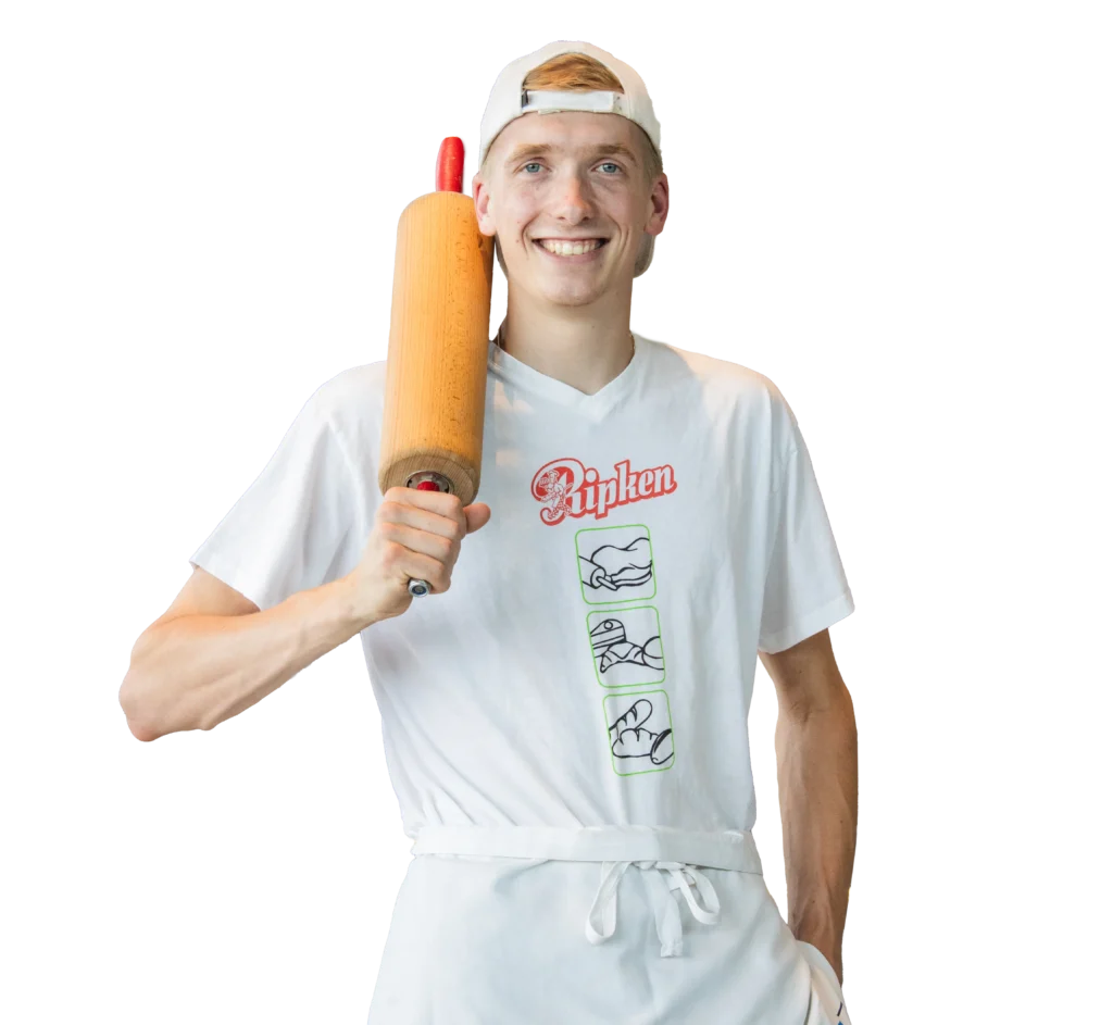 Ein lächelnder junger Mann mit weißer Mütze, T-Shirt und Schürze hält ein hölzernes Nudelholz über seine Schulter. Sein Hemd trägt die Aufschrift Rijpen und zeigt drei handgezeichnete Bilder. Der Hintergrund ist transparent.