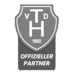 Ein schildförmiges Logo in Graustufen mit V T D und 1902 innen und OFFIZIELLER PARTNER darunter auf einem rechteckigen Sockel.